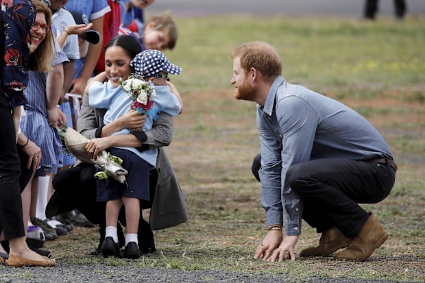 Prince Harry and Meghan, Duchess of Sussex are embraced by Luke Vincent, 5, on their arrival in Dubbo, Australia, Wednesday, Oct. 17, 2018. 