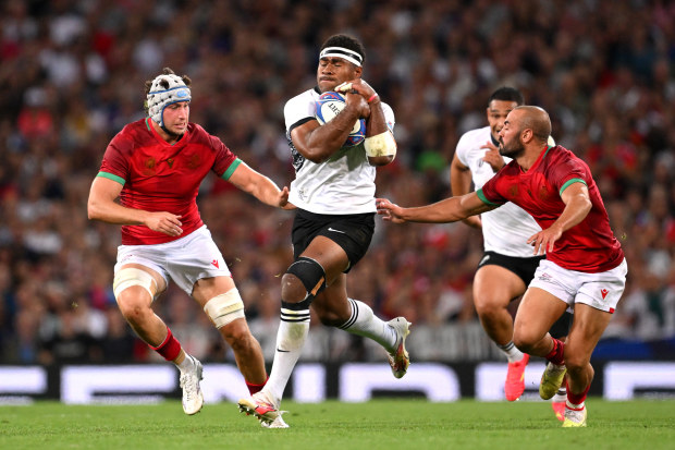 Vinaya Habosi of Fiji runs with the ball whilst under pressure from David Wallis and Samuel Marques of Portugal.