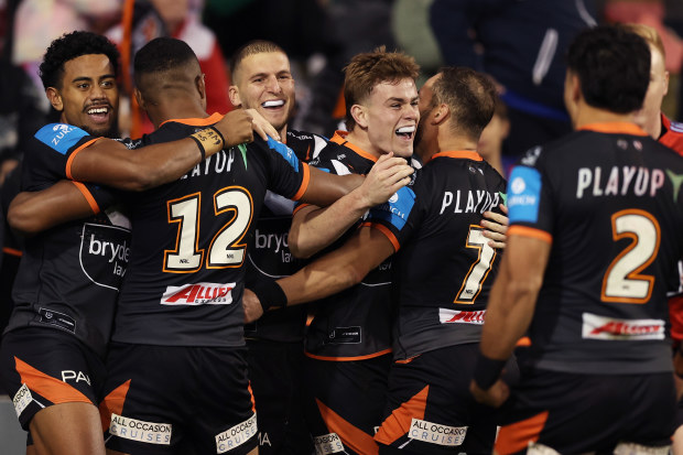 Lachlan Galvin of the Tigers celebrates with teammates after scoring a try.