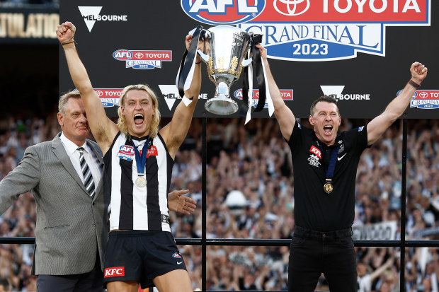 MELBOURNE, AUSTRALIA - SEPTEMBER 30: (L-R) Peter Moore, Darcy Moore of the Magpies and Craig McRae, Senior Coach of the Magpies hold the cup aloft during the 2023 AFL Grand Final match between the Collingwood Magpies and the Brisbane Lions at the Melbourne Cricket Ground on September 30, 2023 in Melbourne, Australia. (Photo by Michael Willson/AFL Photos via Getty Images)