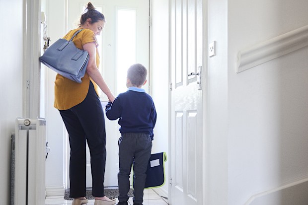 Mum leading son out for school. 