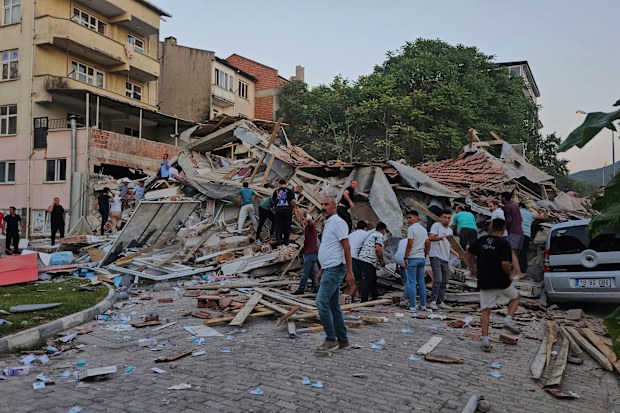 People remove the wreckage of a collapsed building following an earthquake in Sindirgi, northwest Turkey.