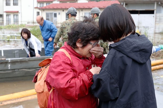 A woman, front left, cries in relief after being rescued from a flooded residential area following Typhoon Hagibis, in Marumori town, Miyagi prefecture, Japan Monday, Oct. 14, 2019.