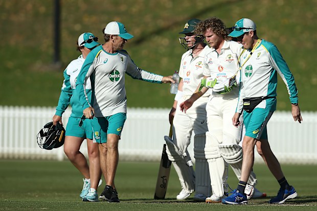 Will Pucovski of Australia A is assisted from the field after been struck in the helmet.
