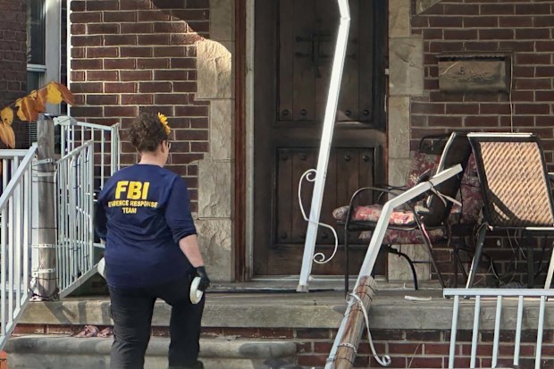 An FBI agent enters a home in Dearborn, Michigan, USA