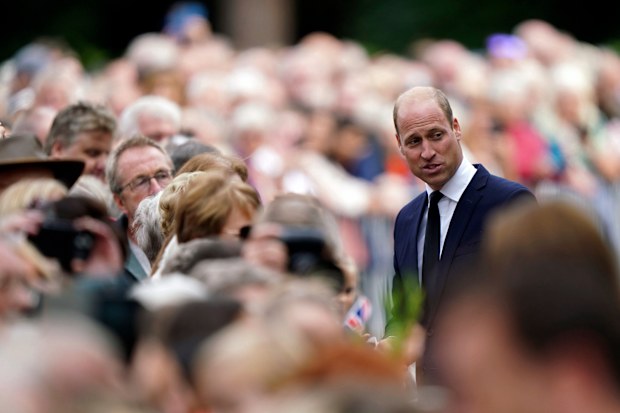 Britain's Prince William meets members of the public after viewing floral tributes to late Queen Elizabeth II at the gates of Sandringham House.