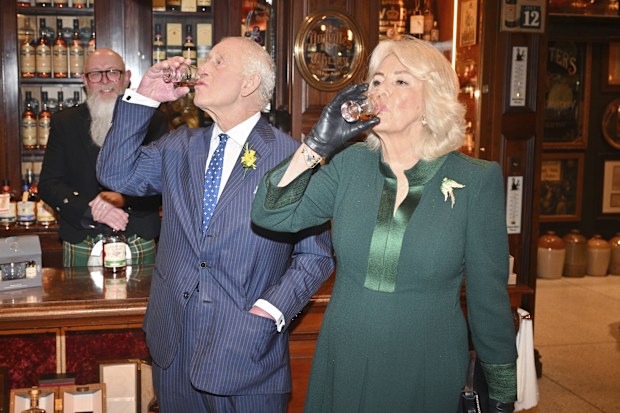 King Charles III and Queen Camilla taste whiskey at The Friend at Hand during a visit to Commercial Court, Belfast, on the first day of their visit to Northern Ireland, Wednesday March 19, 2025. (Samir Hussein/PA via AP)