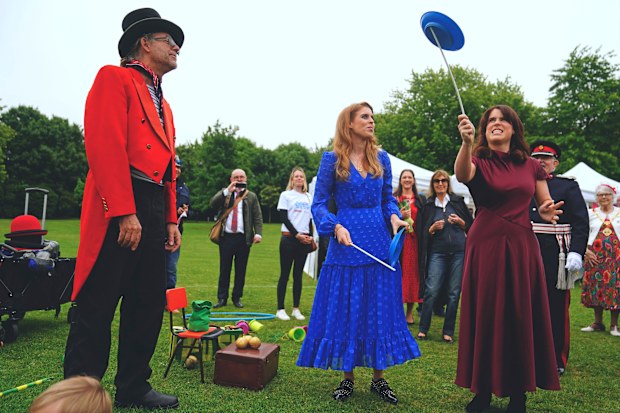 Princess Beatrice, centre, and Princess Eugenie attempt to spin plates during the Big Jubilee Lunch organized by Westminster Council