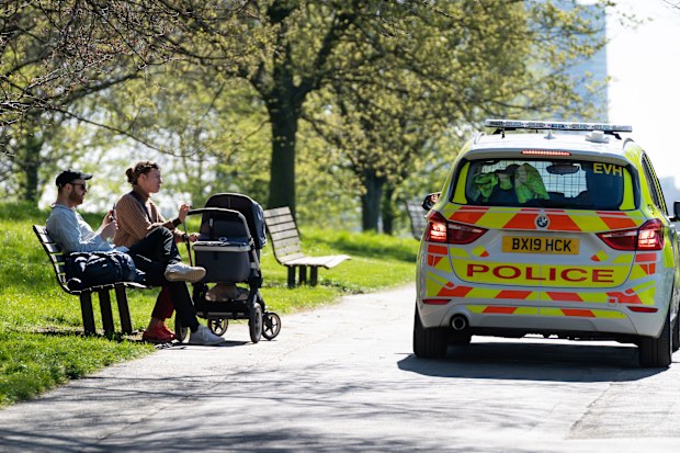 Police ask people to move on, in Primrose Hill, London, Sunday April 5, 2020, as the UK continues in lockdown to help curb the spread of the coronavirus. The new coronavirus causes mild or moderate symptoms for most people, but for some, especially older adults and people with existing health problems, it can cause more severe illness or death. (Aaron Chown/PA via AP)
