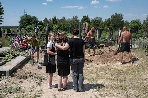 Nataliia Slavhorodska, sister of Ihor Slavhorodskyi, is comforted by her daughter and a relative as men bury the coffin with the body of her brother, in Bucha, Ukraine. Ukrainian soldier Ihor Slavhorodskyi, 58, died in Luhansk Region on June 2, 2022. The Ukrainian government has not released current totals of combat casualties, but officials have been emphasising the country's mounting losses.