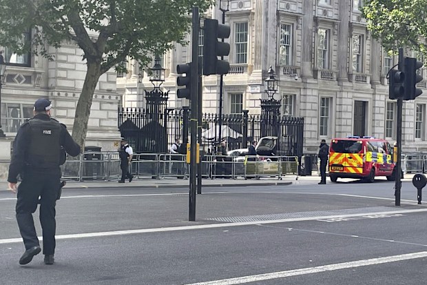 Police at the scene after a car collided with the gates of Downing Street, in London, Thursday May 25, 2023. 