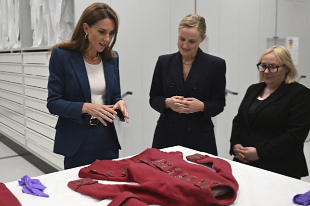 Catherine, Princess of Wales, left, with Oriole Cullen, the Senior Fashion and Textiles Curator, center, and Kate Parsons, the Director of Collections Care and Access, with a 19th century riding habit at the V&A East Storehouse, a brand-new cultural destination in east London, by the director of the V&A, Tristram Hunt, Tuesday June 10, 2025. (Eddie Mulholland/Pool via AP)