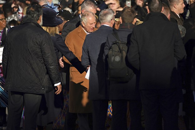 Close-protection officers usher Britain's King Charles III out of the way as he was meeting members of the public during a visit to Luton, England, Tuesday Dec. 6, 2022. 