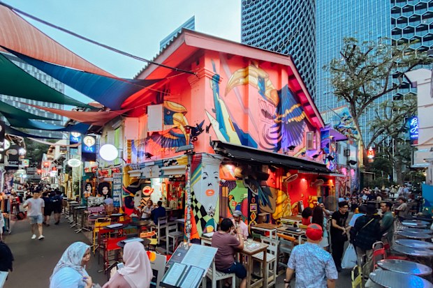 In the middle east inspired Haji Lane pub and shopping street in Singapore people rest and drink beers at the many bars or just walk along the street and do window shopping.
