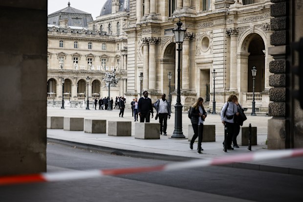 Staff leave the Louvre Museum as people are evacuated after it received a written threat, in Paris, Saturday Oct. 14, 2023.  