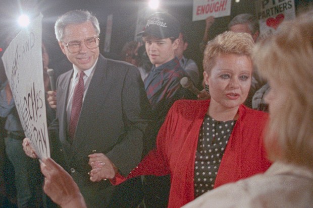 Jim Bakker and wife Tammy Faye Bakker greet supporters as they leave federal court in Charlotte. 