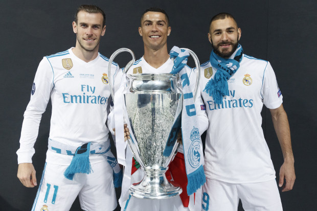 Real Madrid's Cristiano Ronaldo holds the trophy as he poses for a picture with his teammates Karim Benzema and Gareth Bale.