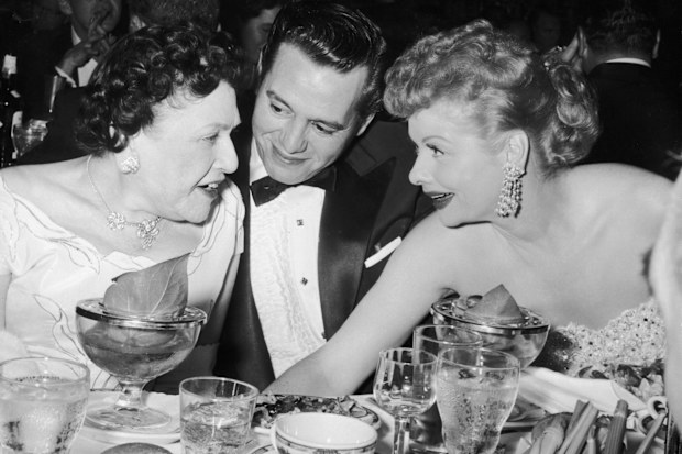 Desi Arnaz and Lucille Ball chat with Hollywood gossip columnist Louella Parsons (left) at the Golden Globe Awards in 1956.