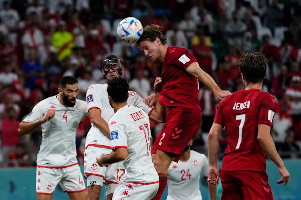 Denmark's Joachim Andersen, top, heads the ball during the World Cup group D soccer match between Denmark and Tunisia, at the Education City Stadium in Al Rayyan, Qatar, Tuesday, Nov. 22, 2022. The match ended in a 0-0 draw 