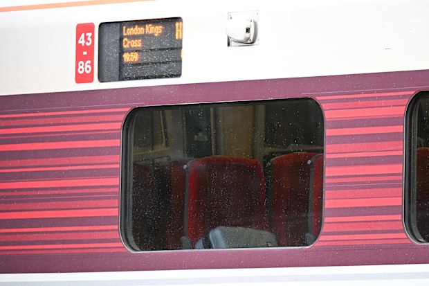 A passengers belongings are seen through the window as emergency services attend to the train.
