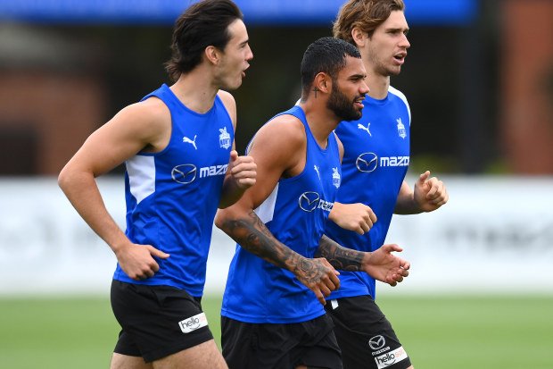 Tarryn Thomas jogs with teammates Eddie Ford and Kallan Dawson during pre-season training.