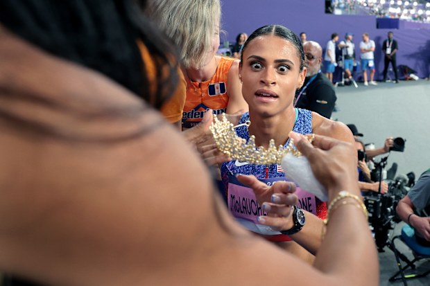 Sydney McLaughlin-Levrone receives a crown from her sister-in-law. 