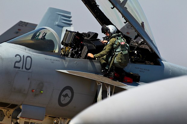 A F/A-18F crewmember from 1 Squadron climbs from his aircraft after arriving at RAAF Base Darwin. (AAP)