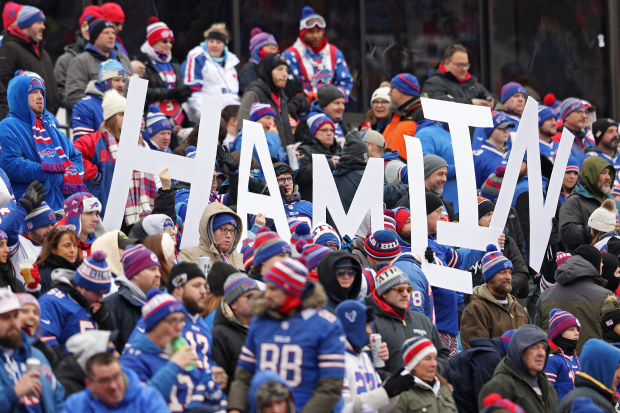 Buffalo Bills fans hold signs in support of Damar Hamlin.
