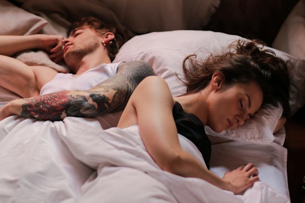 Stock photo of a woman and man in bed together.