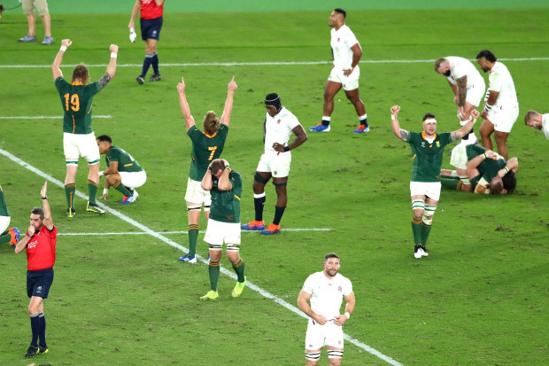 Players of South Africa celebrate victory as the England team react to defeat as referee Jerome Garces blows his whistle during the Rugby World Cup 2019 final.