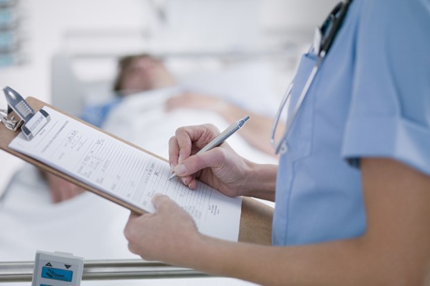 nurse tending to patient istock
