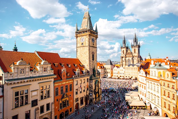 Cityscape view on the clock tower and Tyn cathedral on the old square in Prague.