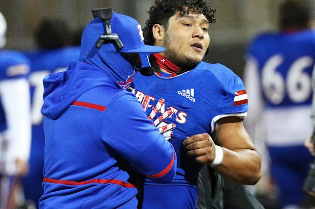 Edinburg High's Emmanuel Duron is pulled from the field by coaching staff after charging a referee.
