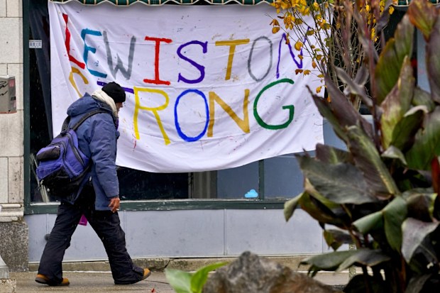 A man walks past a "Lewiston Strong" sign, Sunday, Oct. 29, 2023, in Lewiston, Maine.