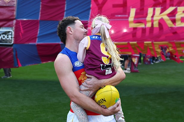 MELBOURNE, AUSTRALIA - APRIL 19: Lachie Neale of the Lions takes to the field with his daughter, Piper, on his 300th game during the round six AFL match between Melbourne Demons and Brisbane Lions at Melbourne Cricket Ground, on April 19, 2026, in Melbourne, Australia. (Photo by Daniel Pockett/AFL Photos/via Getty Images)