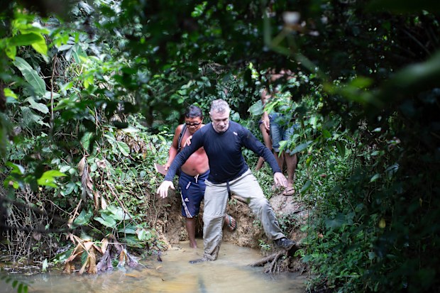 British journalist Dom Phillips, right, and a Yanomami Indigenous man walk in Maloca Papiu village, Roraima state, Brazil, Nov. 2019. Phillips and Indigenous affairs expert Bruno Araujo Pereira have been reported missing in a remote part of Brazil's Amazon region, a local Indigenous association said Monday, June 6, 2022. (AP Photo/Joao Laet)