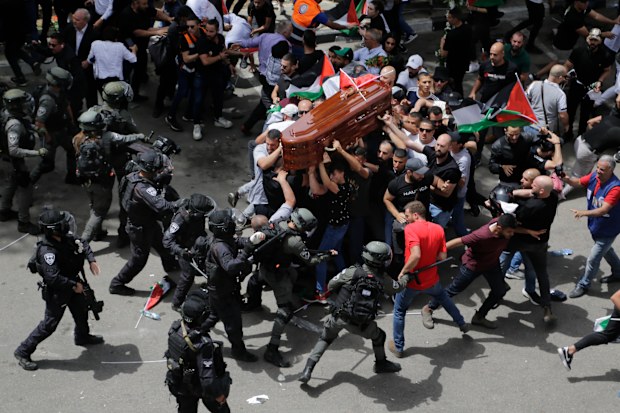 Israeli police confront with mourners as they carry the casket of slain Al Jazeera veteran journalist Shireen Abu Akleh during her funeral in east Jerusalem, Friday, May 13, 2022. Abu Akleh, a Palestinian-American reporter who covered the Mideast conflict for more than 25 years, was shot dead Wednesday during an Israeli military raid in the West Bank town of Jenin. (AP Photo/Maya Levin)