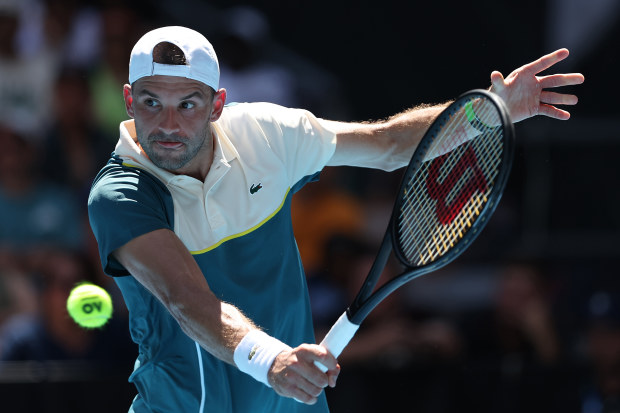 MELBOURNE, AUSTRALIA - JANUARY 16: Grigor Dimitrov of Bulgaria plays a backhand in their round one singles match against Marton Fucsovics of Hungary during the 2024 Australian Open at Melbourne Park on January 16, 2024 in Melbourne, Australia. (Photo by Phil Walter/Getty Images)