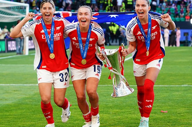 Kyra Cooney-Cross of Arsenal WFC (L) with Caitlin Foord of Arsenal WFC (C) and Steph Catley of Arsenal WFC (R) celebrate with trophy after winning the UEFA Women's Champions League Final at the end of the UEFA Women's Champions League Final match between FC Barcelona and Arsenal WFC at Estadio Jose Alvalade on May 24, 2025 in Lisbon, Portugal. (Photo by Gualter Fatia/Getty Images)