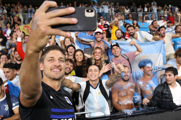 Domingo Miotti of the Pumas takes a photo with fans.