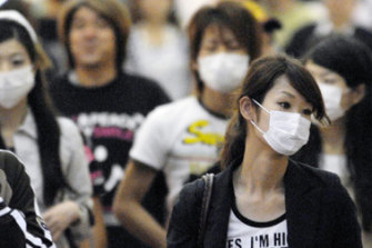 Shoppers in Japan wear masks as precaution against swine flu.