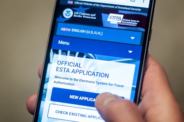 A man accessing the US Department for Homeland Security's official Esta visa waiver application website on his mobile phone. The scheme requires international travellers who are exempt from visa requirements to apply for an Esta, which stands for Electronic System for Travel Authorisation, and pay a small fee - around &Acirc;&pound;10 - before entering the territory. (Photo by Lauren Hurley/PA Images via Getty Images)