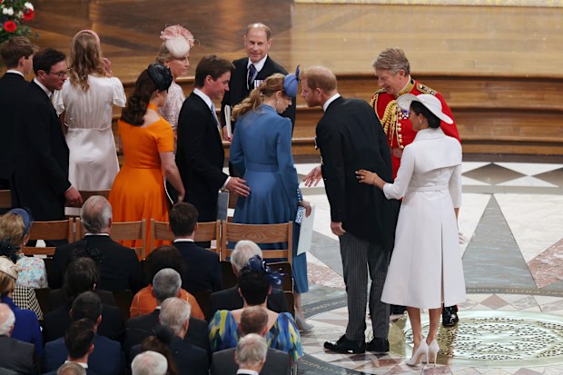Prince Harry and Meghan Markle greet Princess Eugenie and Beatrice in their seats for the Service of Thanksgiving.