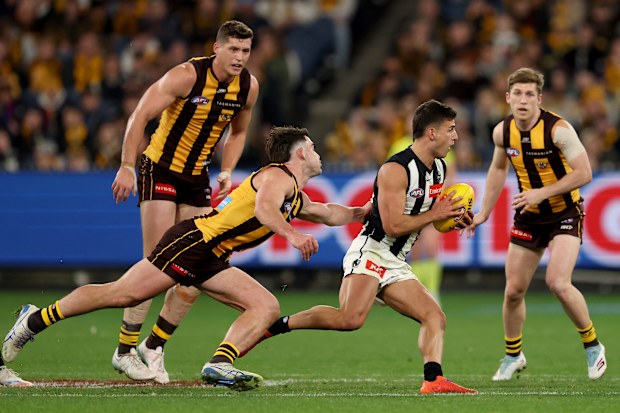  Nick Daicos of the Magpies is tackled by Jai Newcombe of the Hawks.