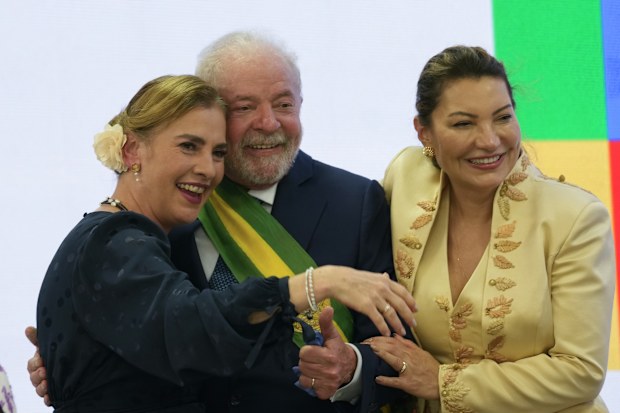 President Luiz Inacio Lula da Silva, center, embraces Beatriz Gutierrez, left, Mexican President Andres Manuel Lopez Obrador's wife and his wife Rosangela Silva after he was sworn in as new president at the Planalto Palace in Brasilia, Brazil, Sunday, Jan. 1, 2023. (AP Photo/Eraldo Peres)
