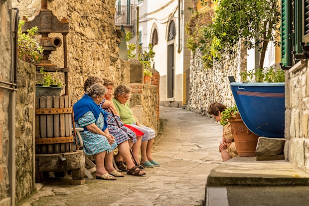 Charming of Corniglia. Local women sitting and talking at the narrow streets of Corniglia, Cinque Terre, Italy