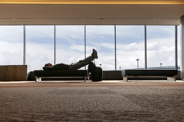 Man sleeping waiting for flight at the airport lounge