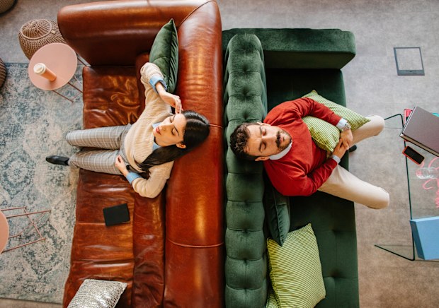 Stock image of a man and woman sitting back to back, looking upset