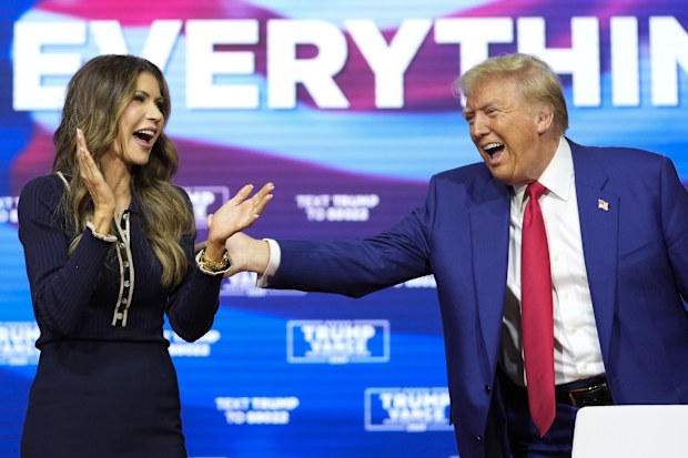 Republican presidential nominee former president Donald Trump reacts with South Dakota Governor Kristi Noem after dancing to the song Y.M.C.A. at a campaign town hall at the Greater Philadelphia Expo Center & Fairgrounds, Monday, Oct. 14, 2024, in Oaks, Pa