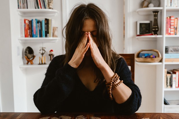 Stock photo of woman crying over a table.